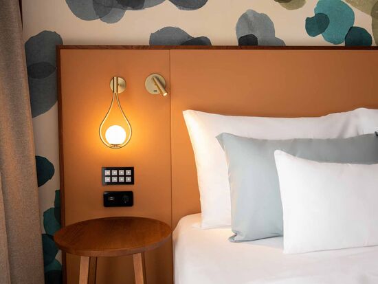 3 cushions on the bed with bedside lamp on