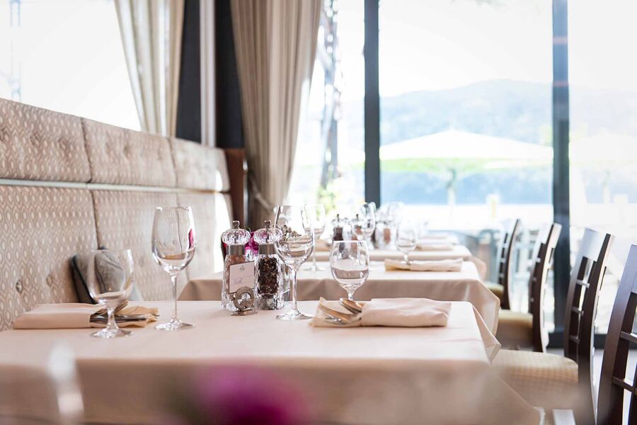 Restaurant mit reich gedeckten Tischen vor Glasscheibe