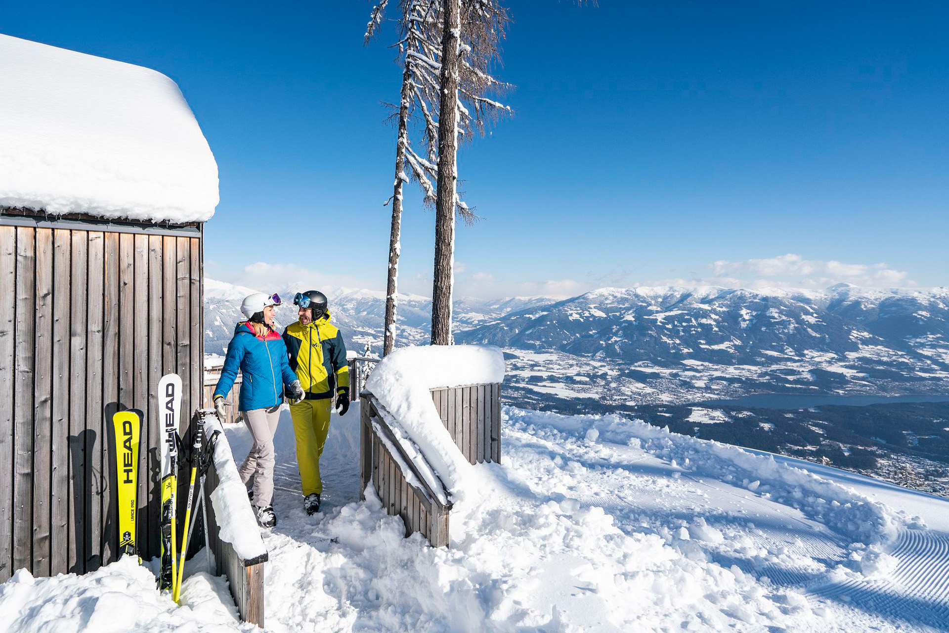 Zwei Skifahrer neben der Holzhütte
