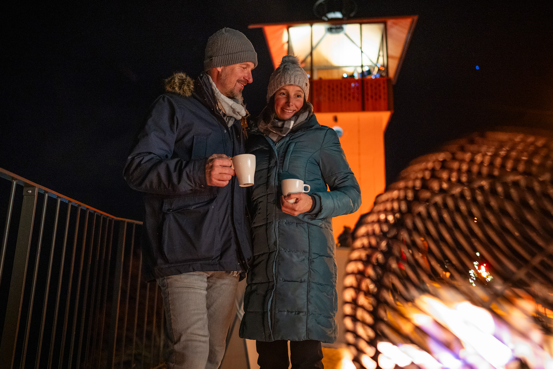Paar mit Tee vor der Feuerstelle