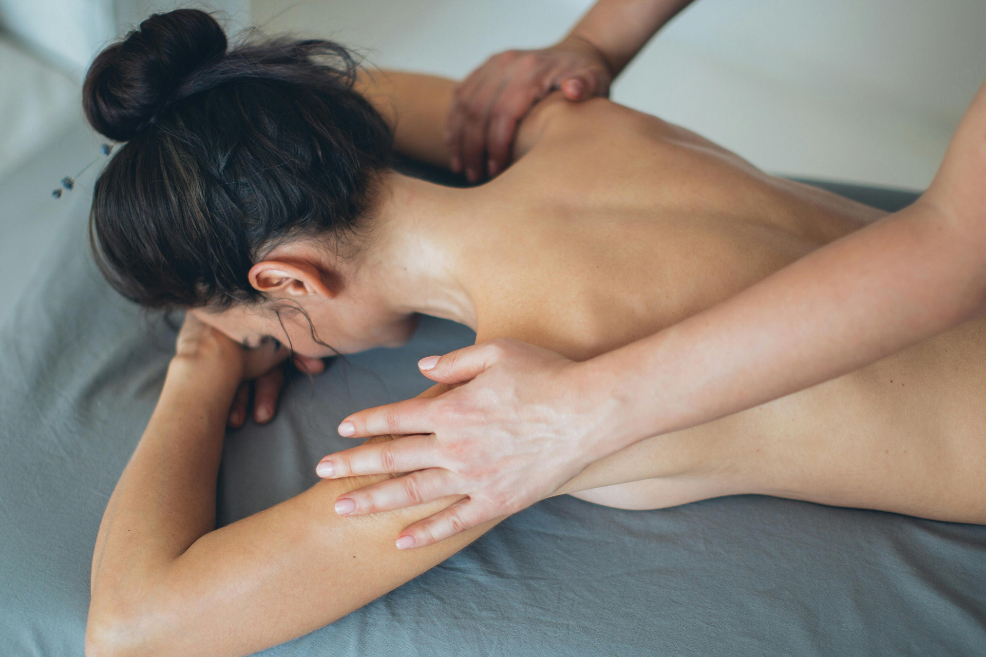 Frau am Bauch liegend bei der Massage