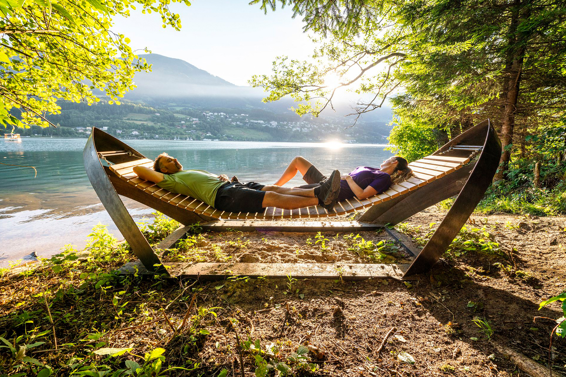 Mann und Frau auf Holzliege in der Sonne