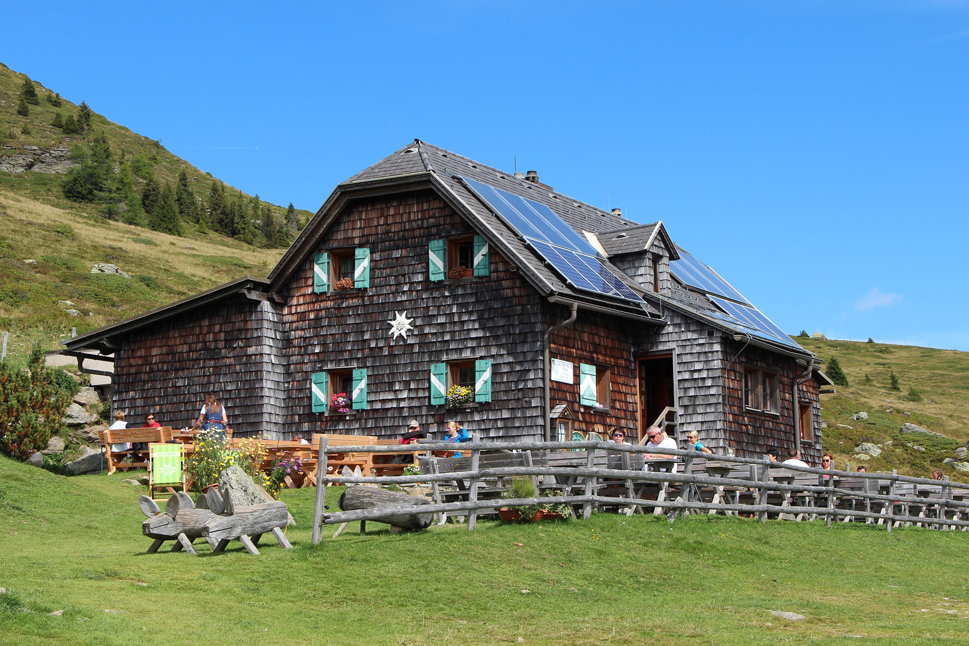 Millstätter Hütte mit Gästen im Freien