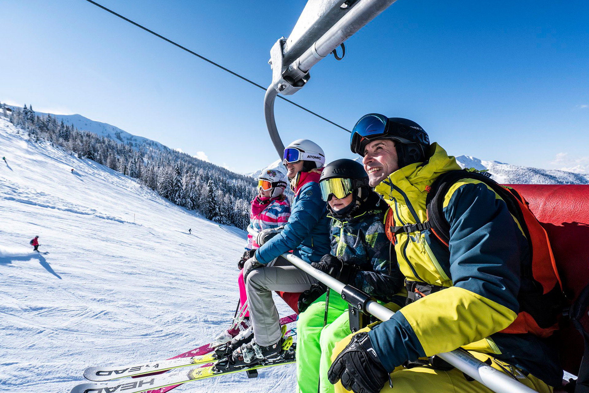Zwei Erwachsene und zwei Kinder auf Sessellift