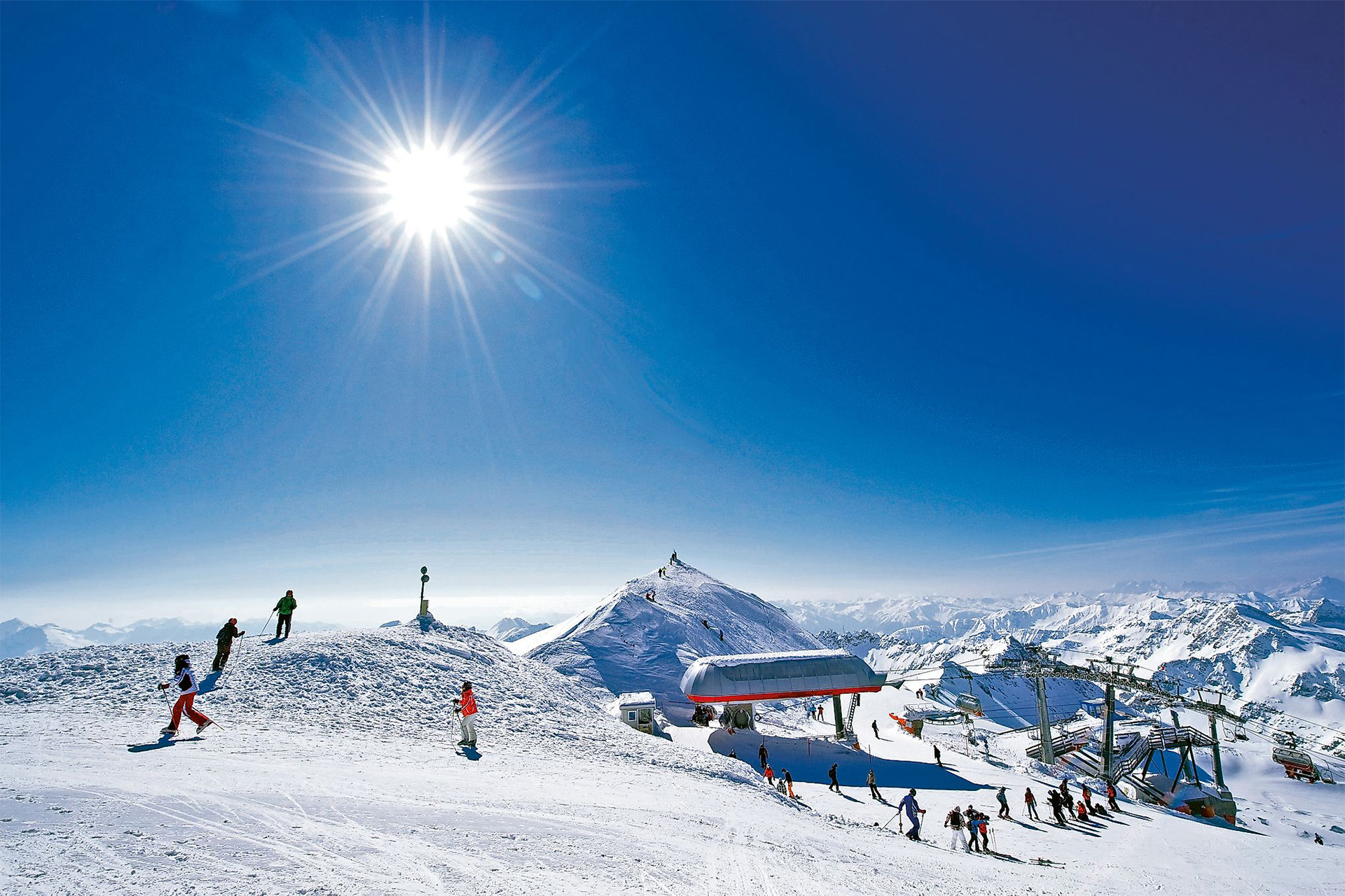 Skifahrer und Liftstation im Sonnenlicht