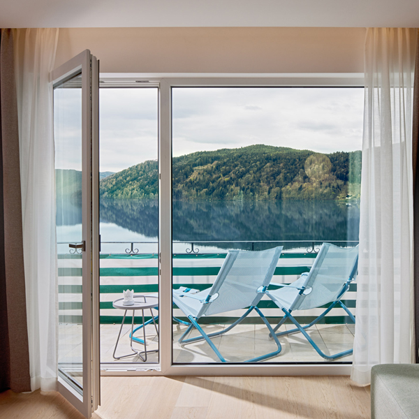 View from the living room to the balcony and the lake with 2 sun chairs