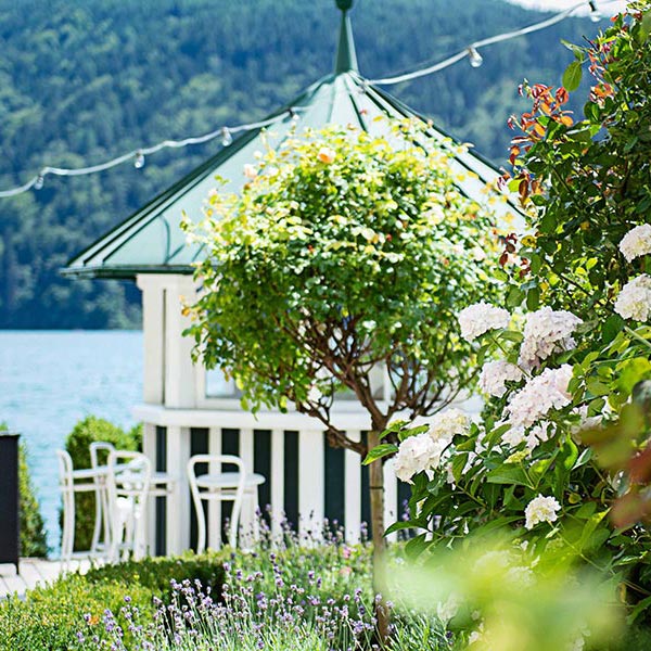 A pavilion stands in front of the lake in the garden of the hotel
