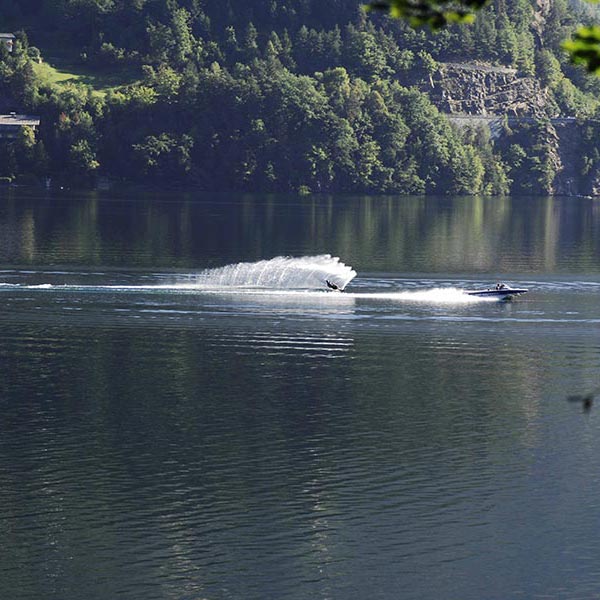 Am See fährt jemanden Wasserski