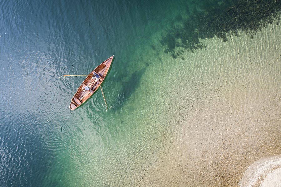 2 persons comfortably rowing along the Lake Millstätter See