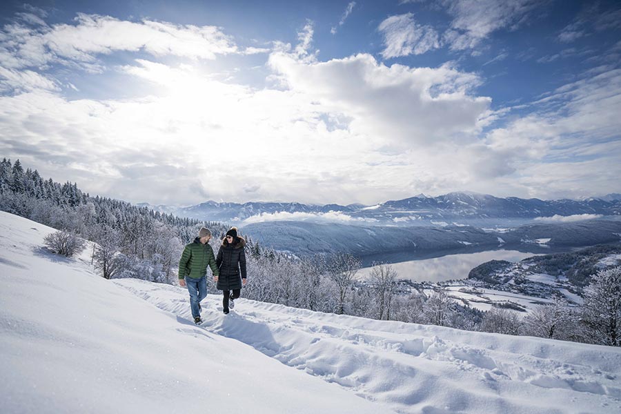 Zwei Menschen gehen Hand in Hand im Schnee spazieren