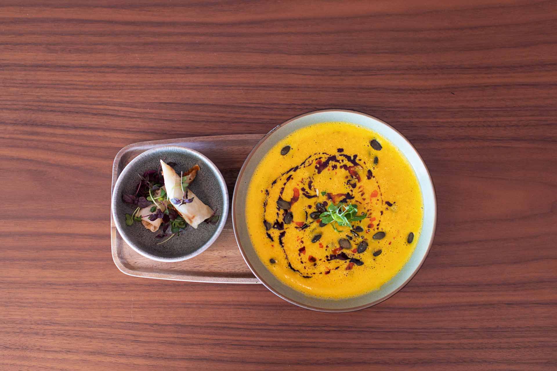 Creamy pumpkin soup on wooden table