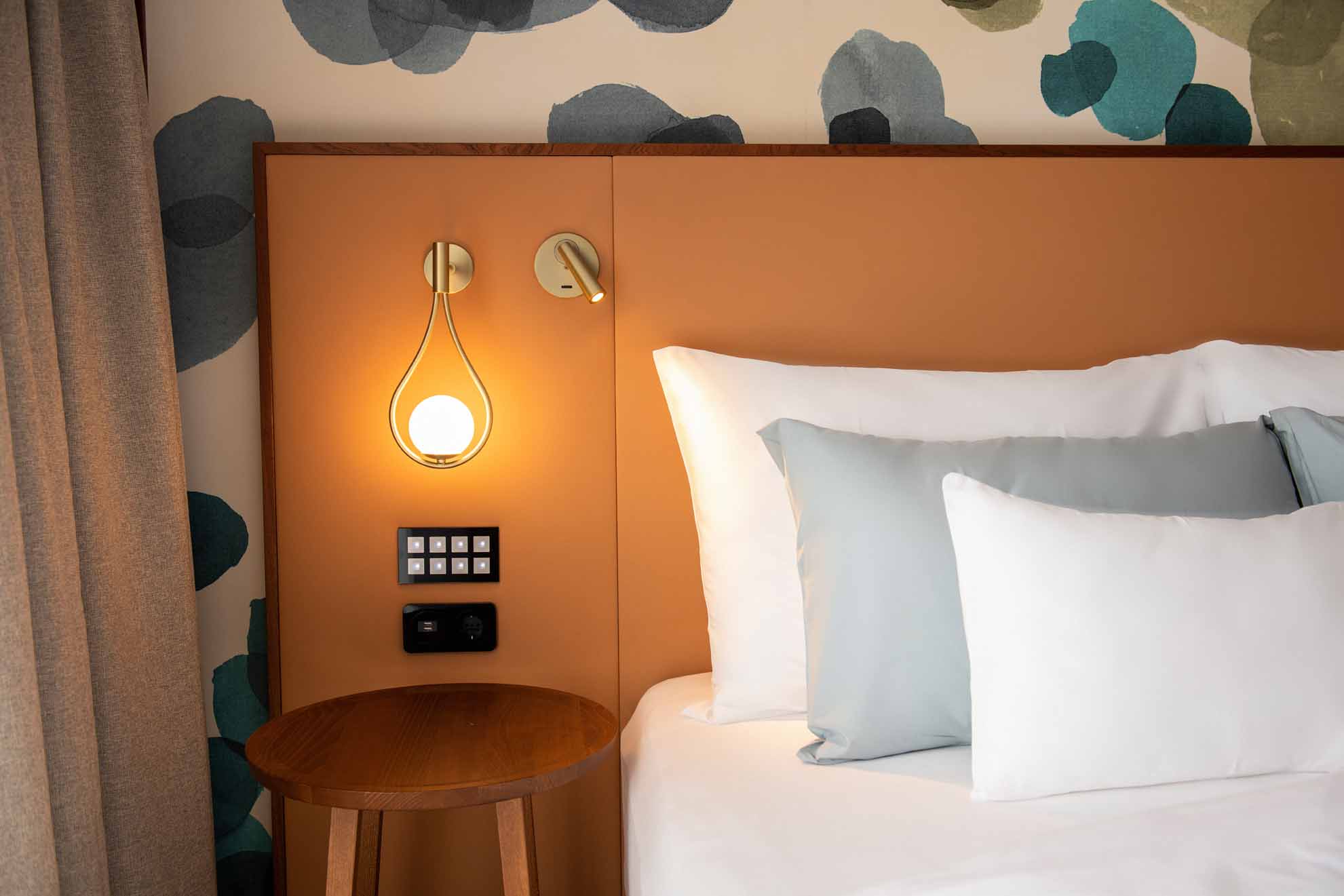 3 cushions on the bed with bedside lamp on