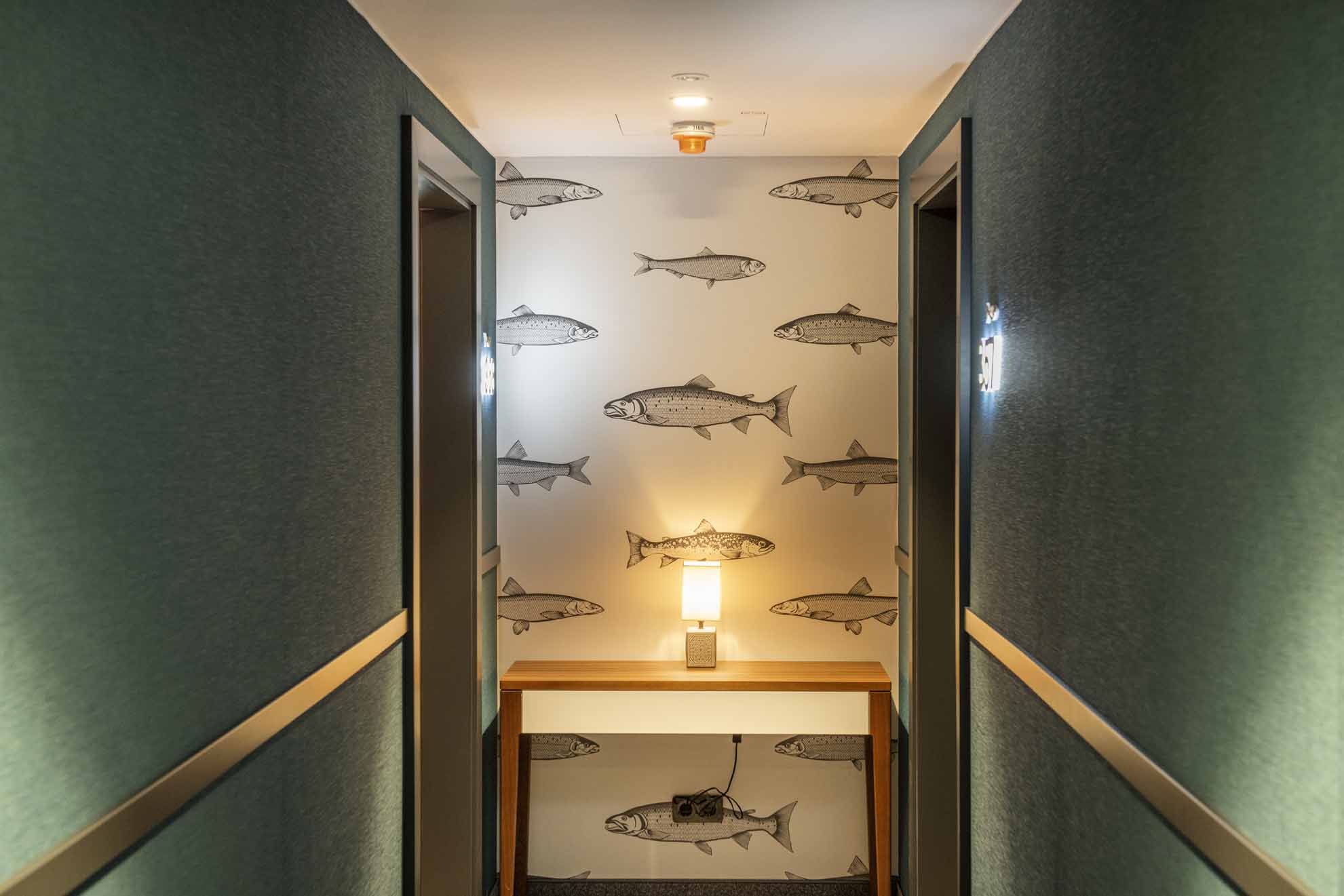 Green corridor to the rooms with fish on the wall
